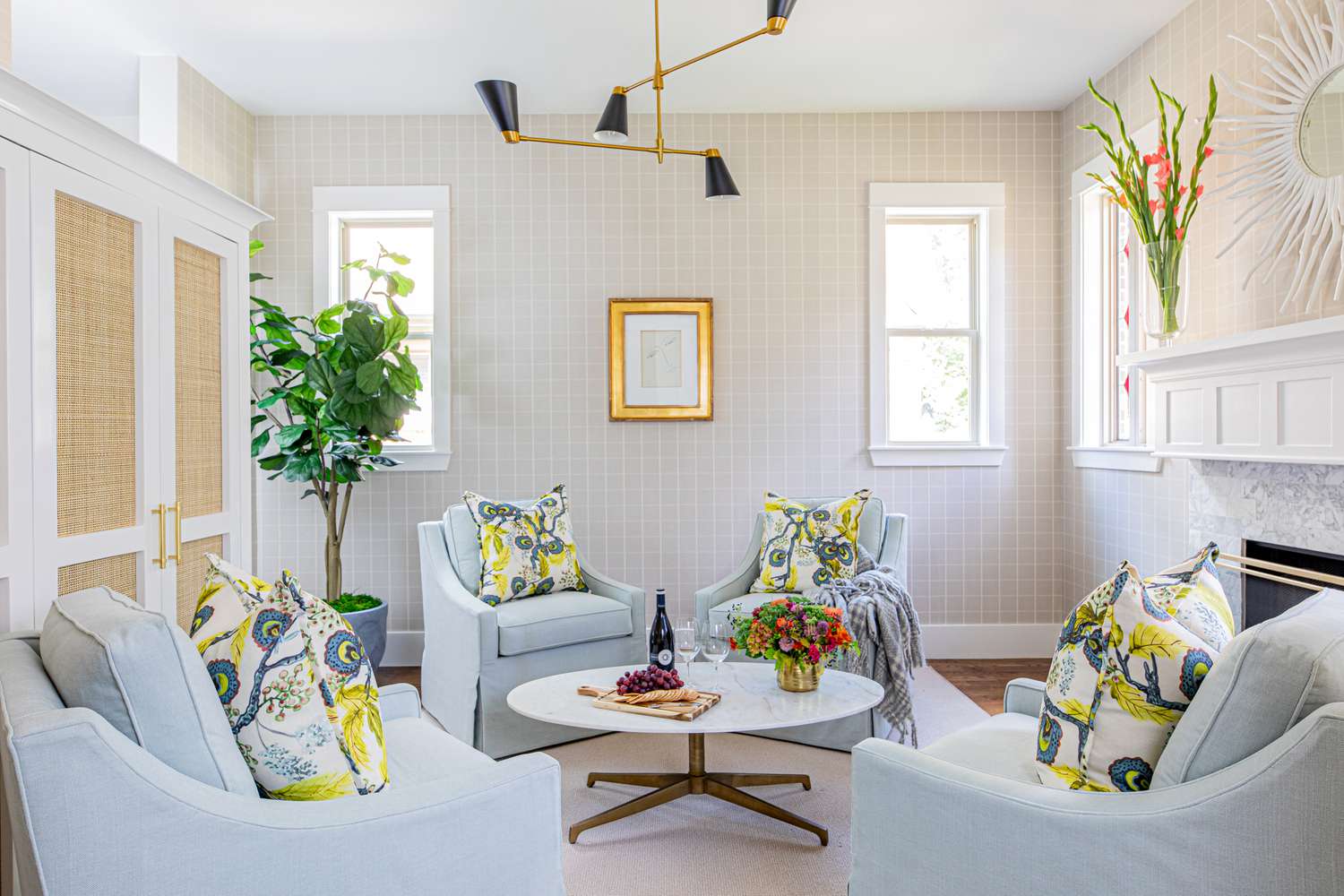 A white living room with yellow pillows and swivel chairs