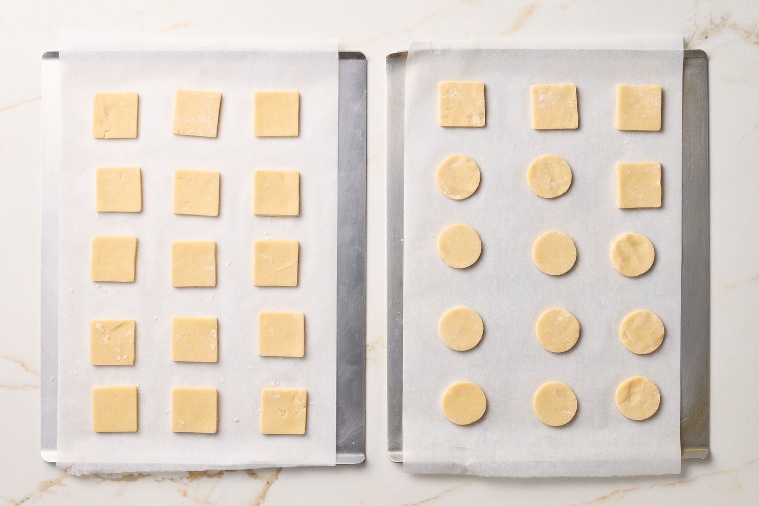 Two baking trays with square and round shortbread cookie dough arranged on parchment paper ready for baking
