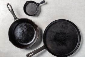 Three cast iron skillets of varying sizes arranged on a surface