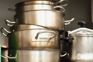 Stacked steel pots and pans in a kitchen setting