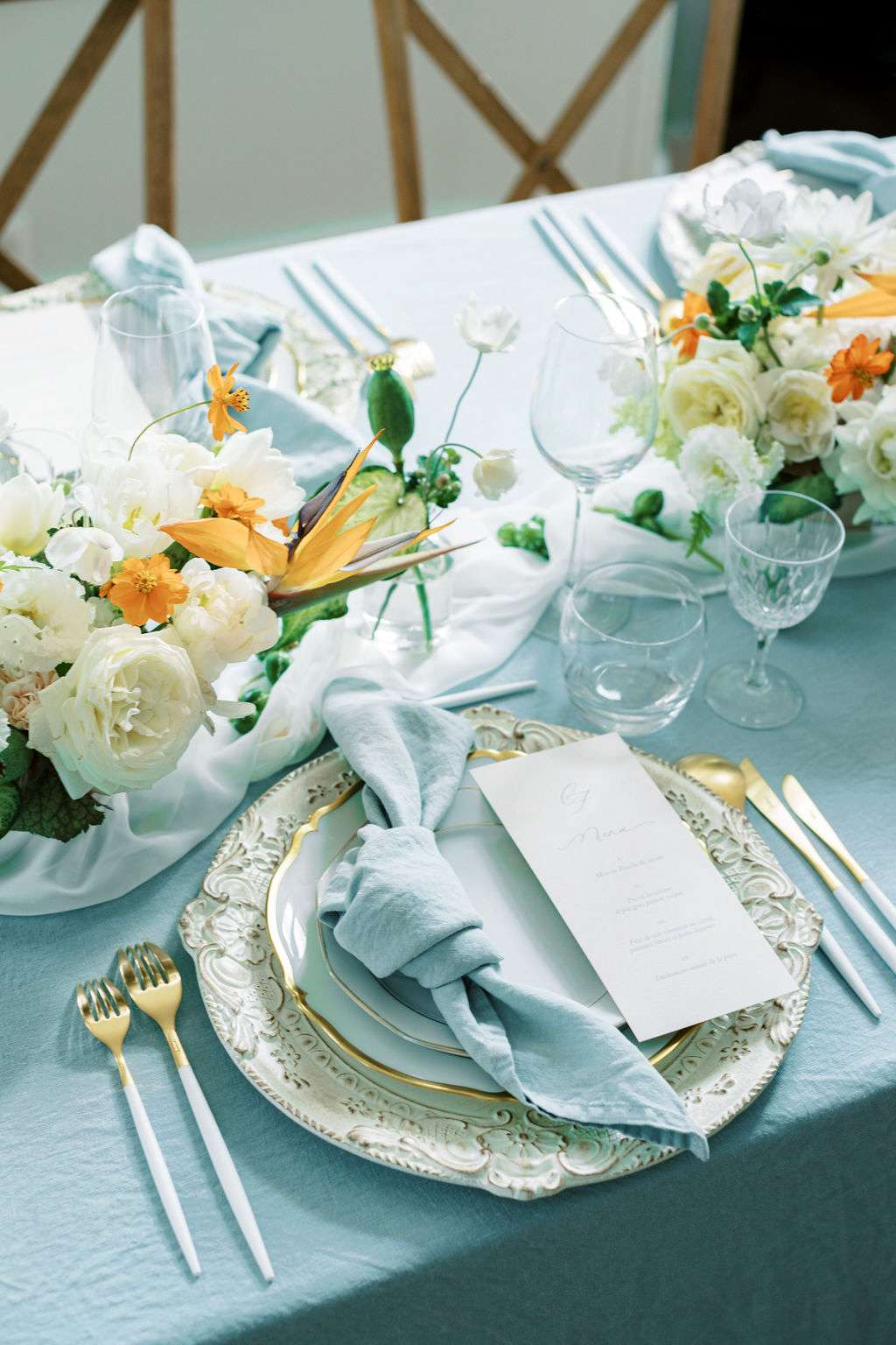 elegant blue, white, and orange place settings with ornate plates and silverware