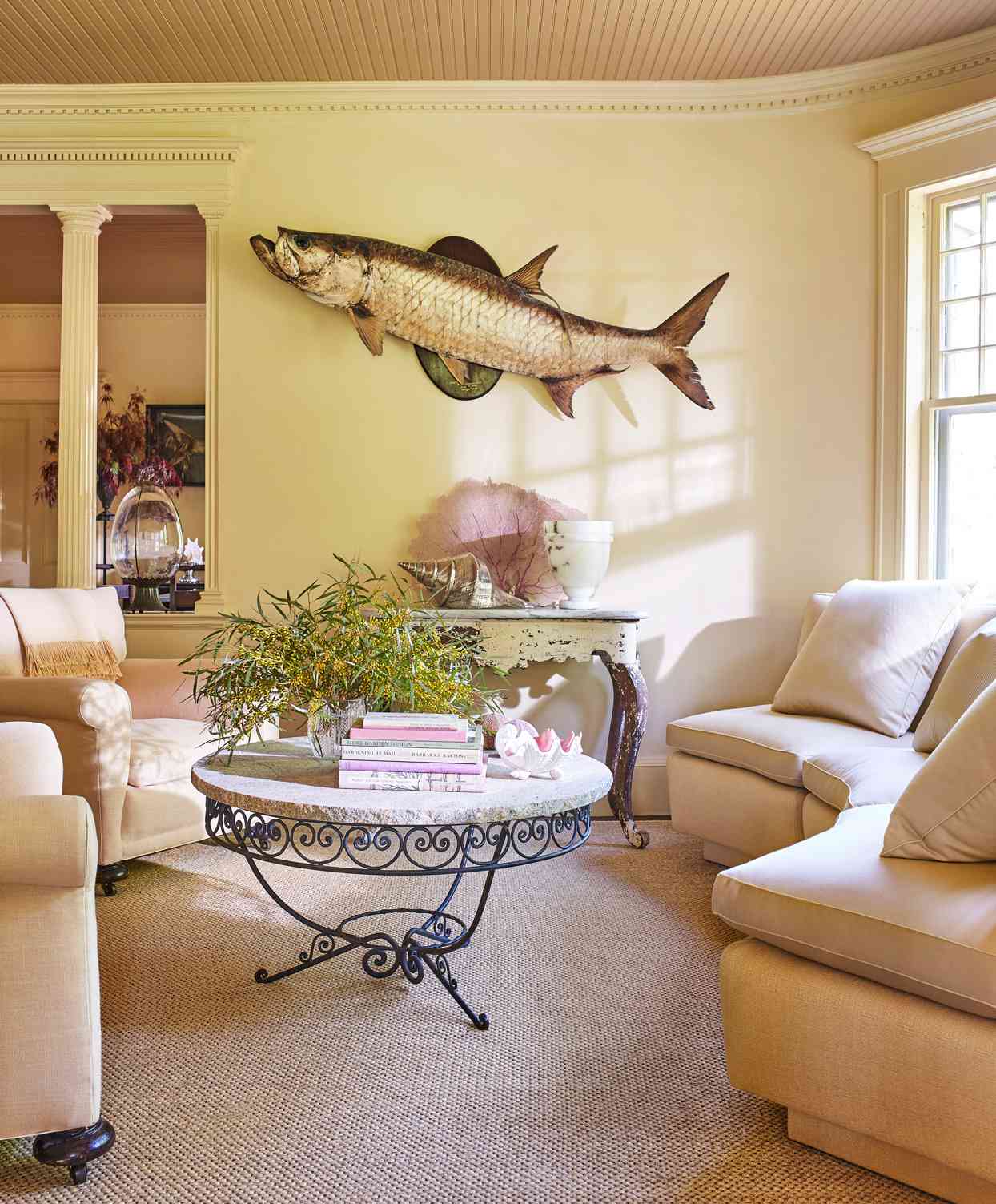 living room with curved linen sofa and taxidermy fish