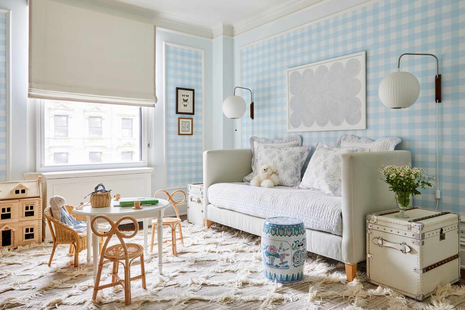 Kid's room with blue gingham wallpaper and light furniture