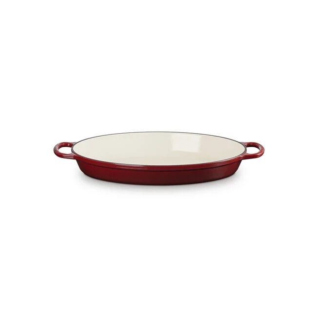 A red enameled stoneware baking dish with handles on either side