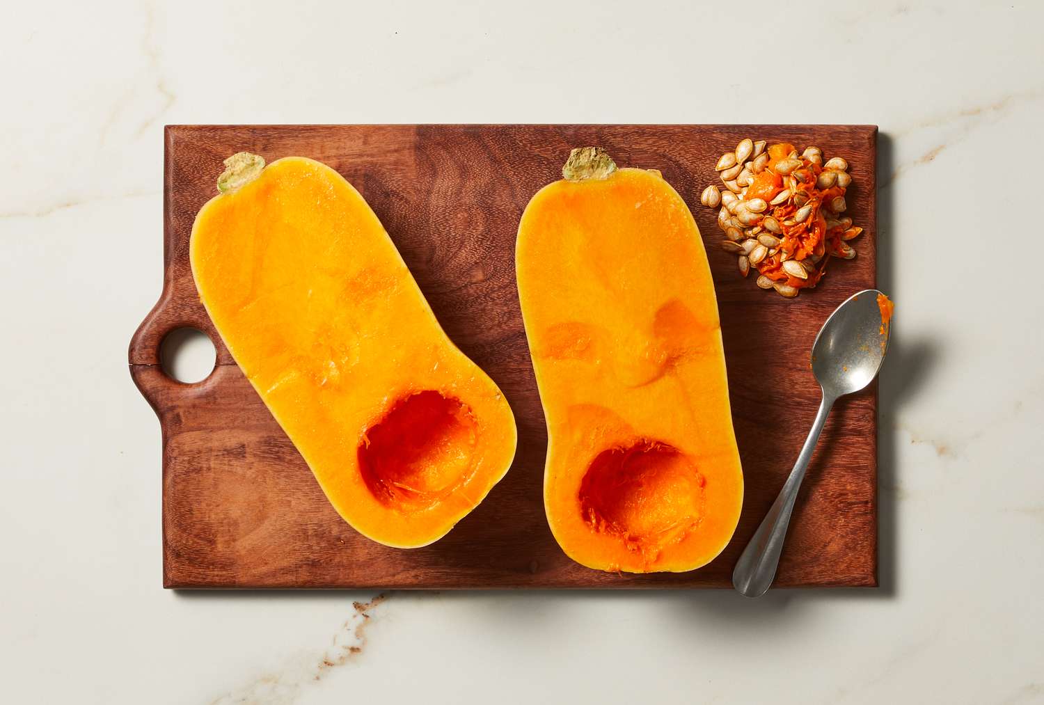 overhead view of raw butternut squash on a cutting board