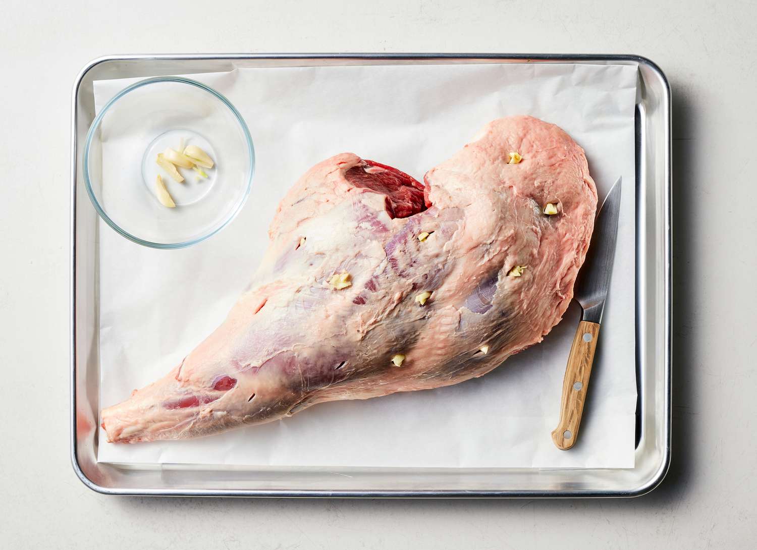 raw leg of lamb on a tray