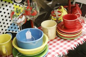 A collection of colorful dishes and glassware displayed on a gingham tablecloth