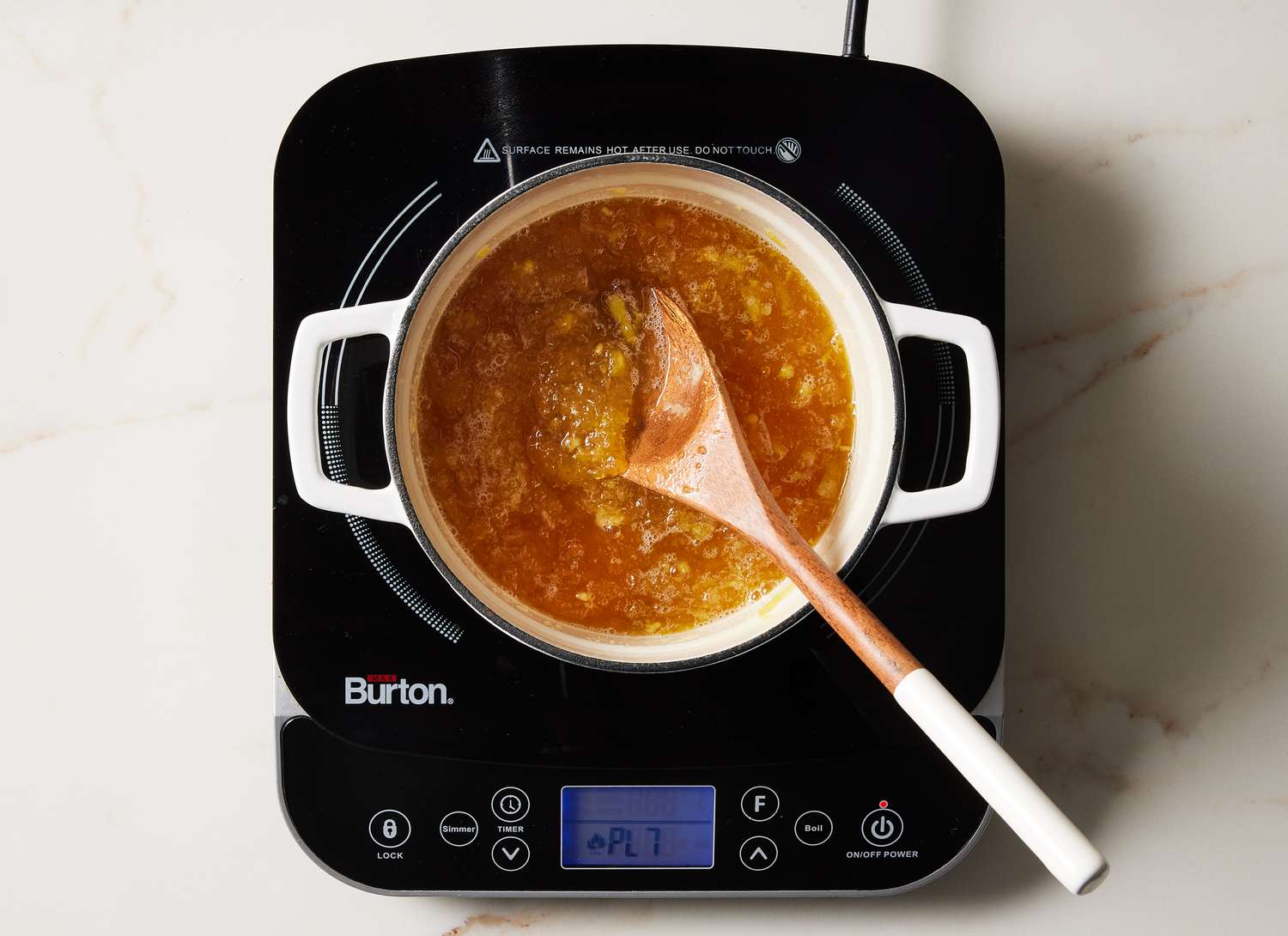 cooked pinapple in a white pot on a cooktop