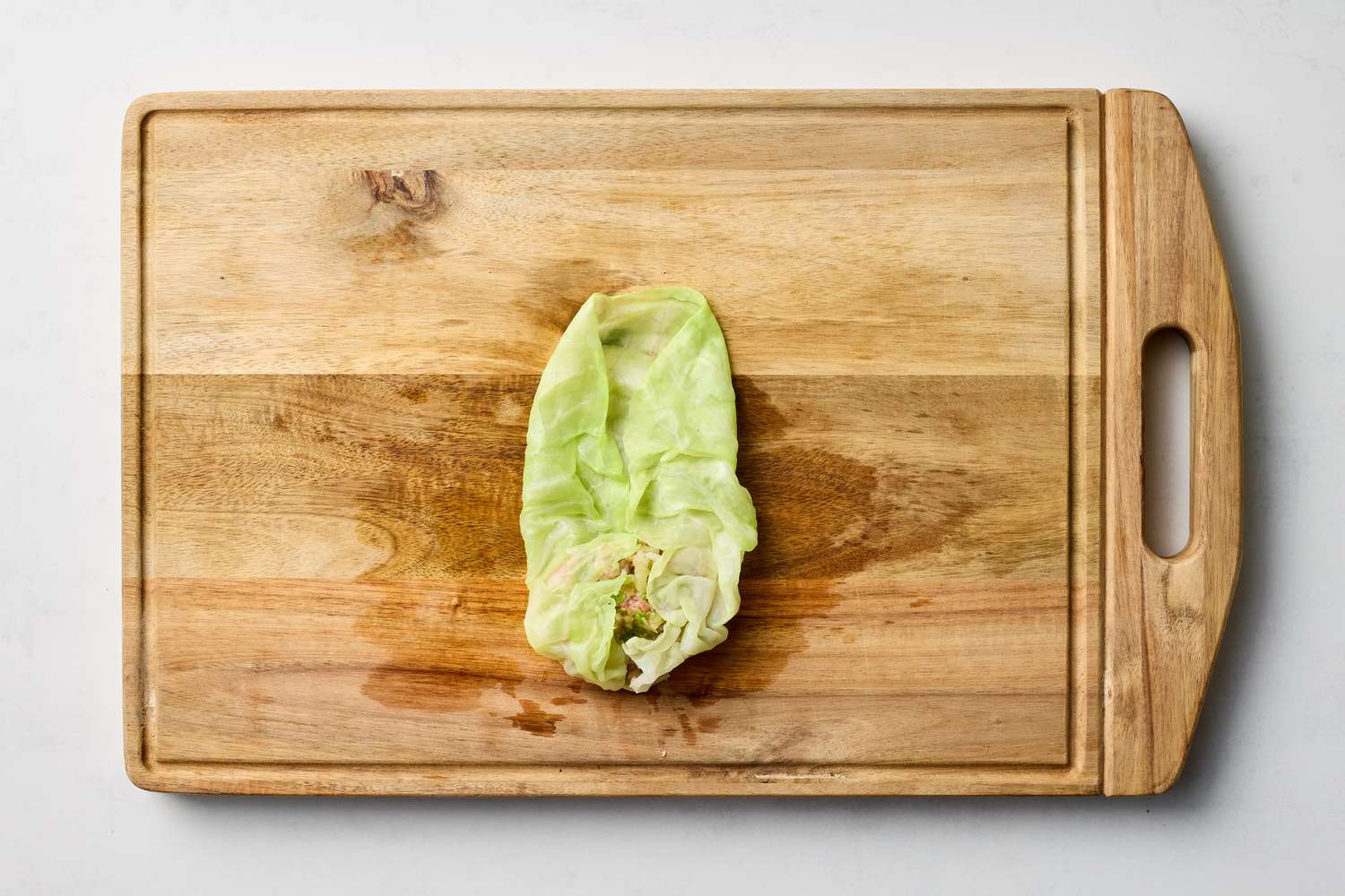 Stuffed cabbage leaf on a wooden cutting board