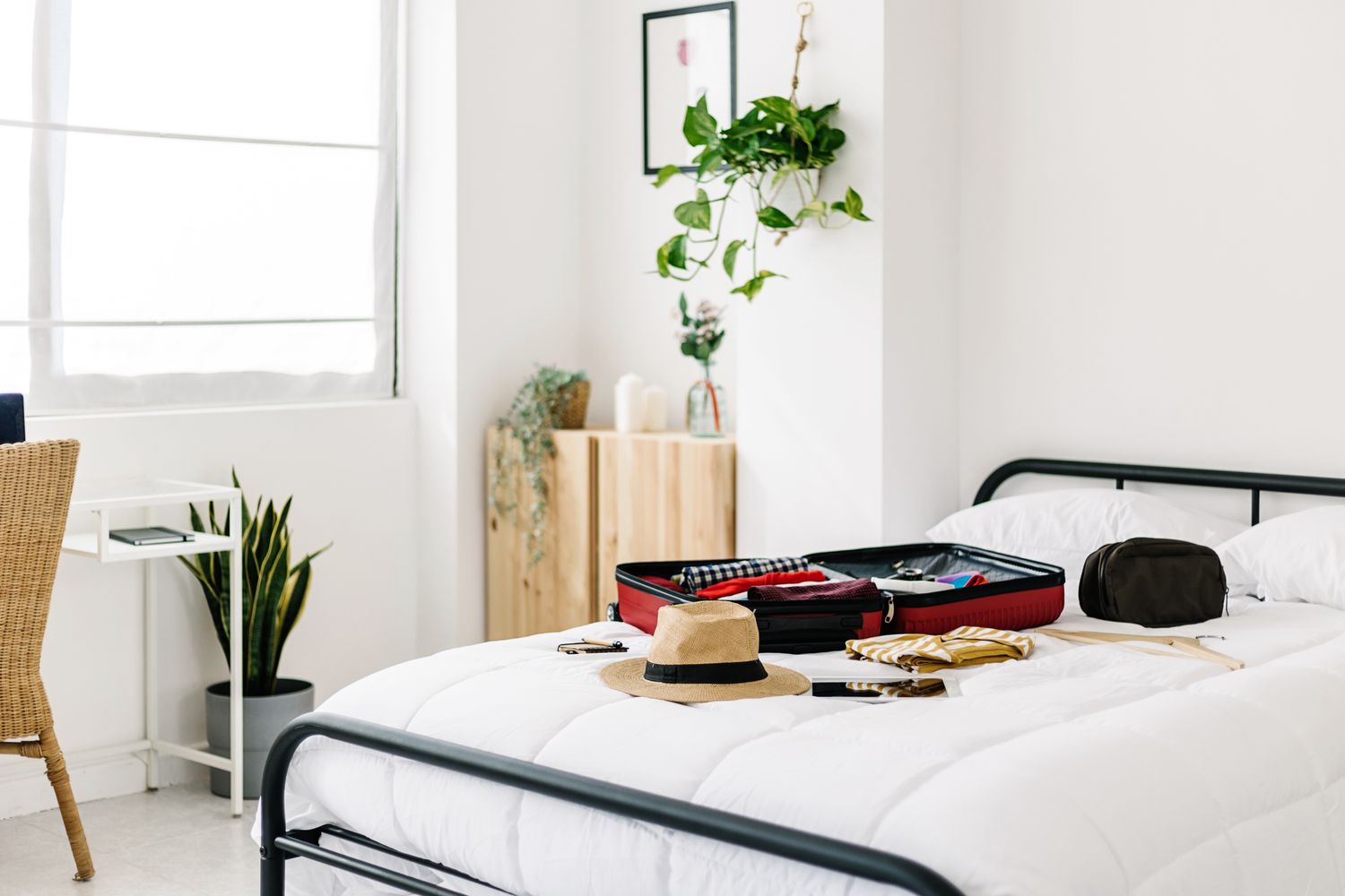 A guest room with a suitcase and travel items placed on a bed