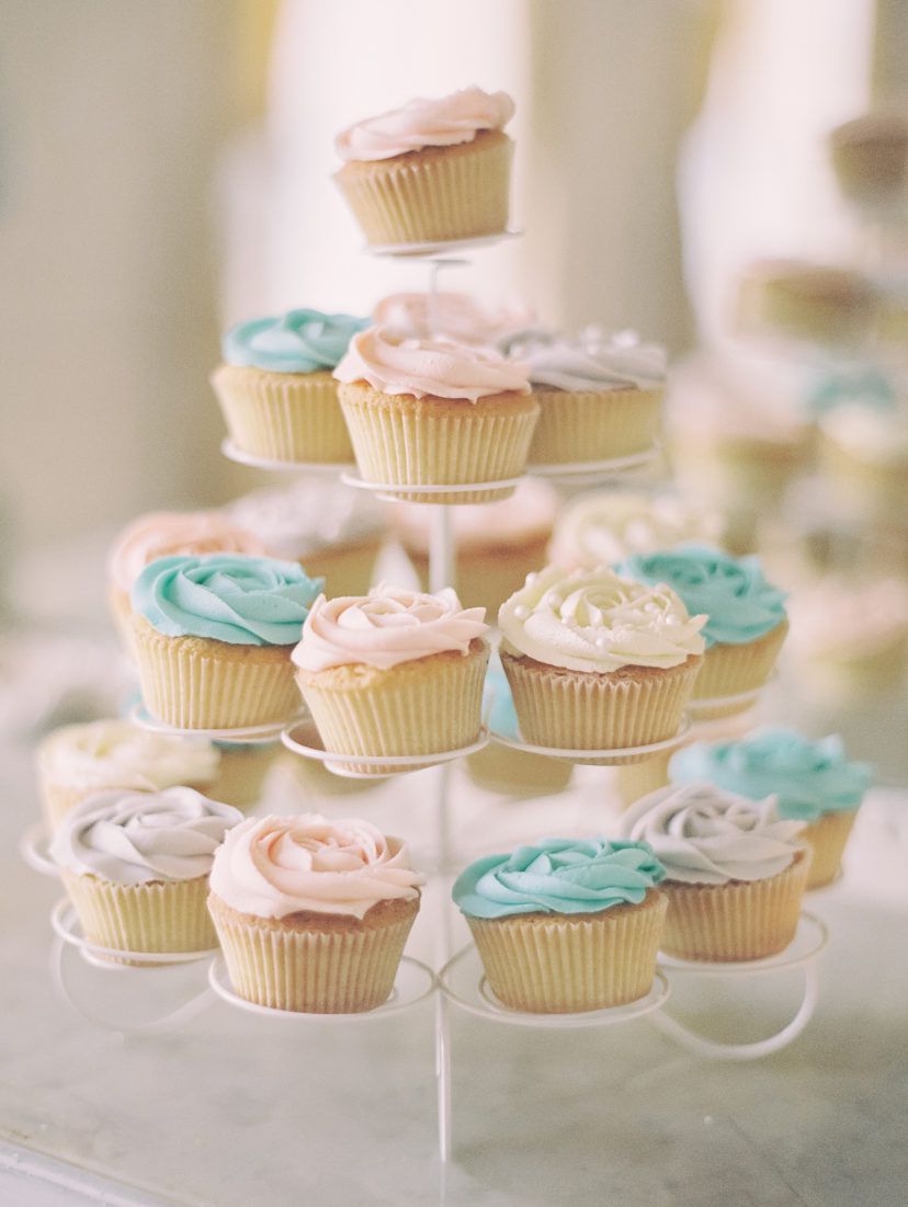 pink blue and white cupcakes on a white stand