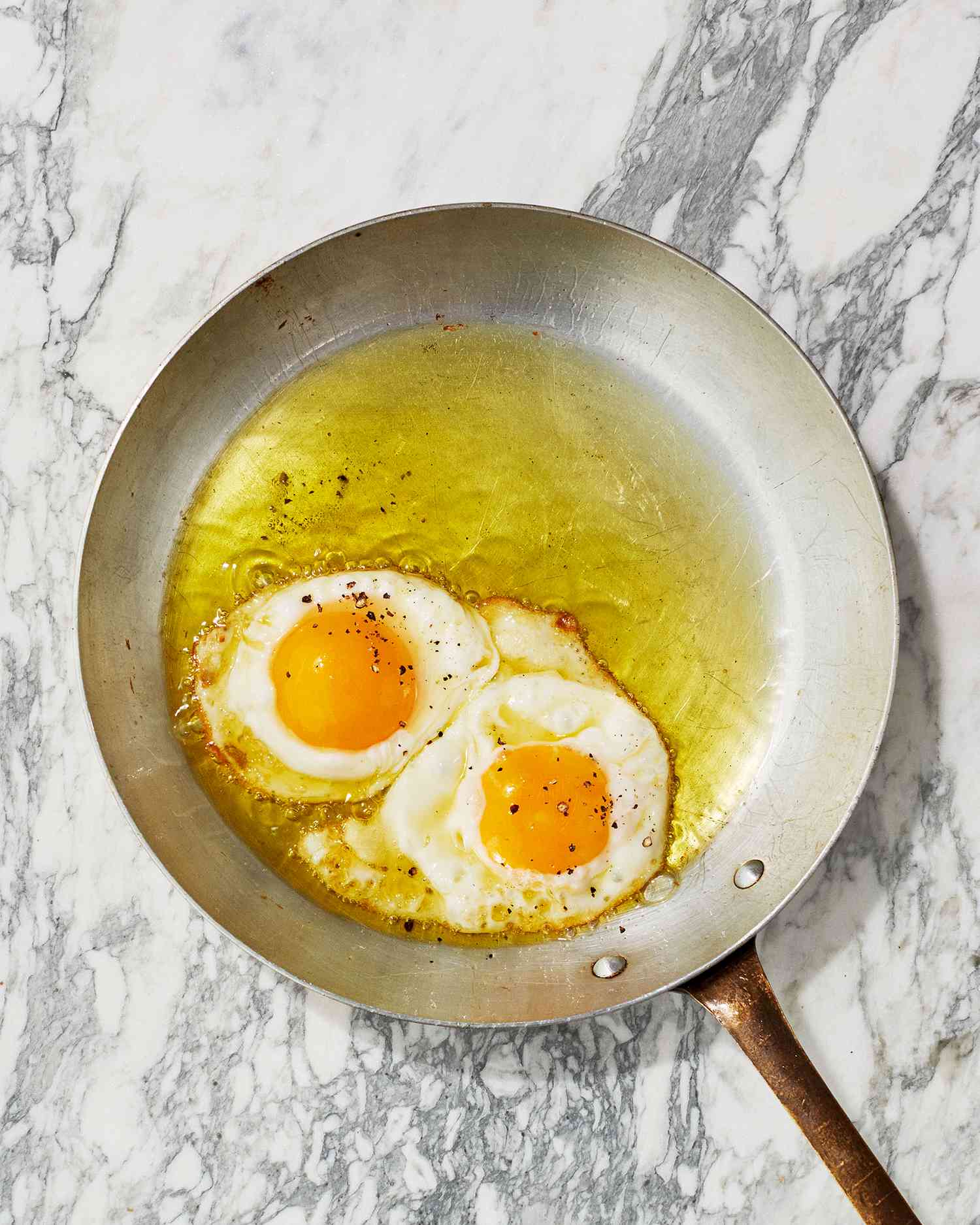 olive-oil fried eggs in pan