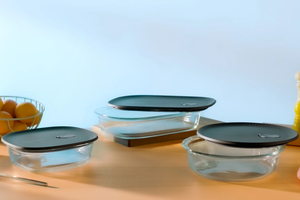 Set of glass food storage containers with black lids on a kitchen counter