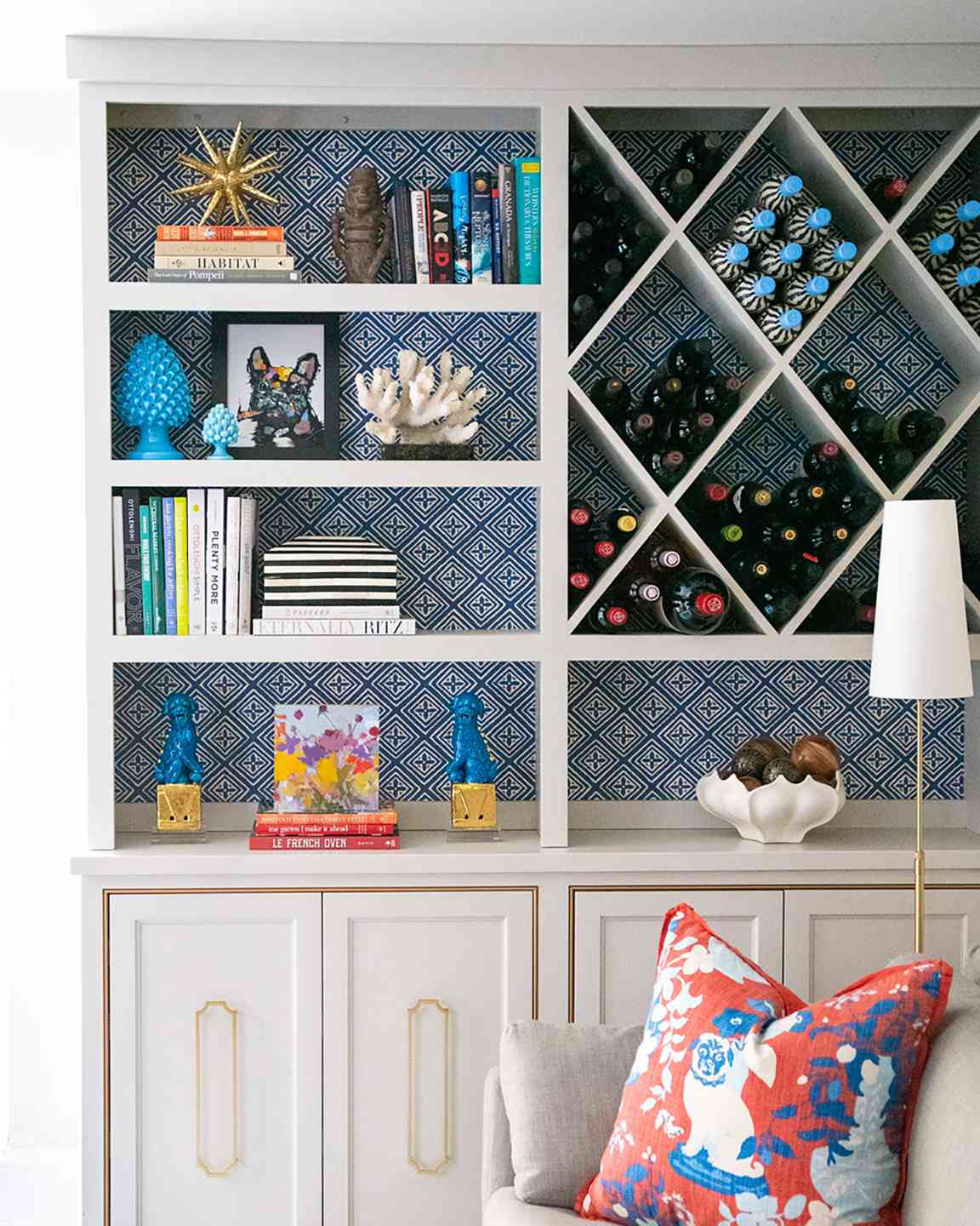 tall shelving with patterned blue wallpaper behind