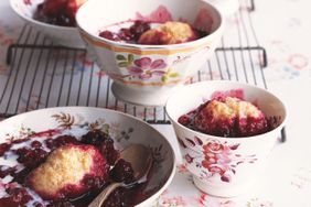 Bowls of a dessert with fruit and a topping, arranged on a floral tableware setting