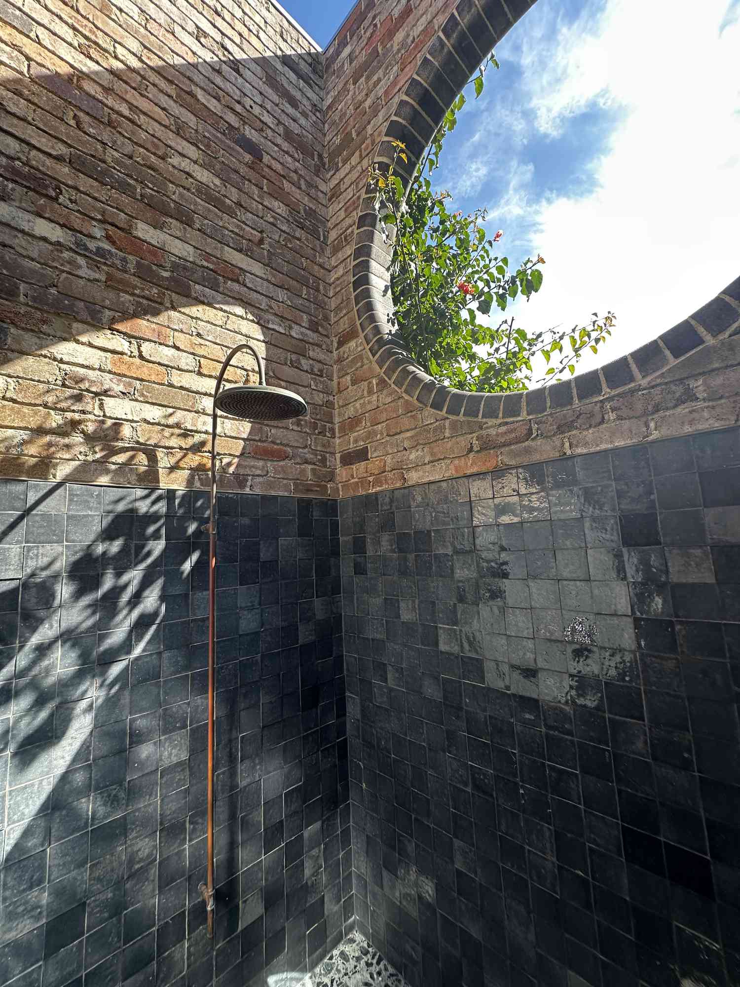 Outdoor shower with brick walls and circle window