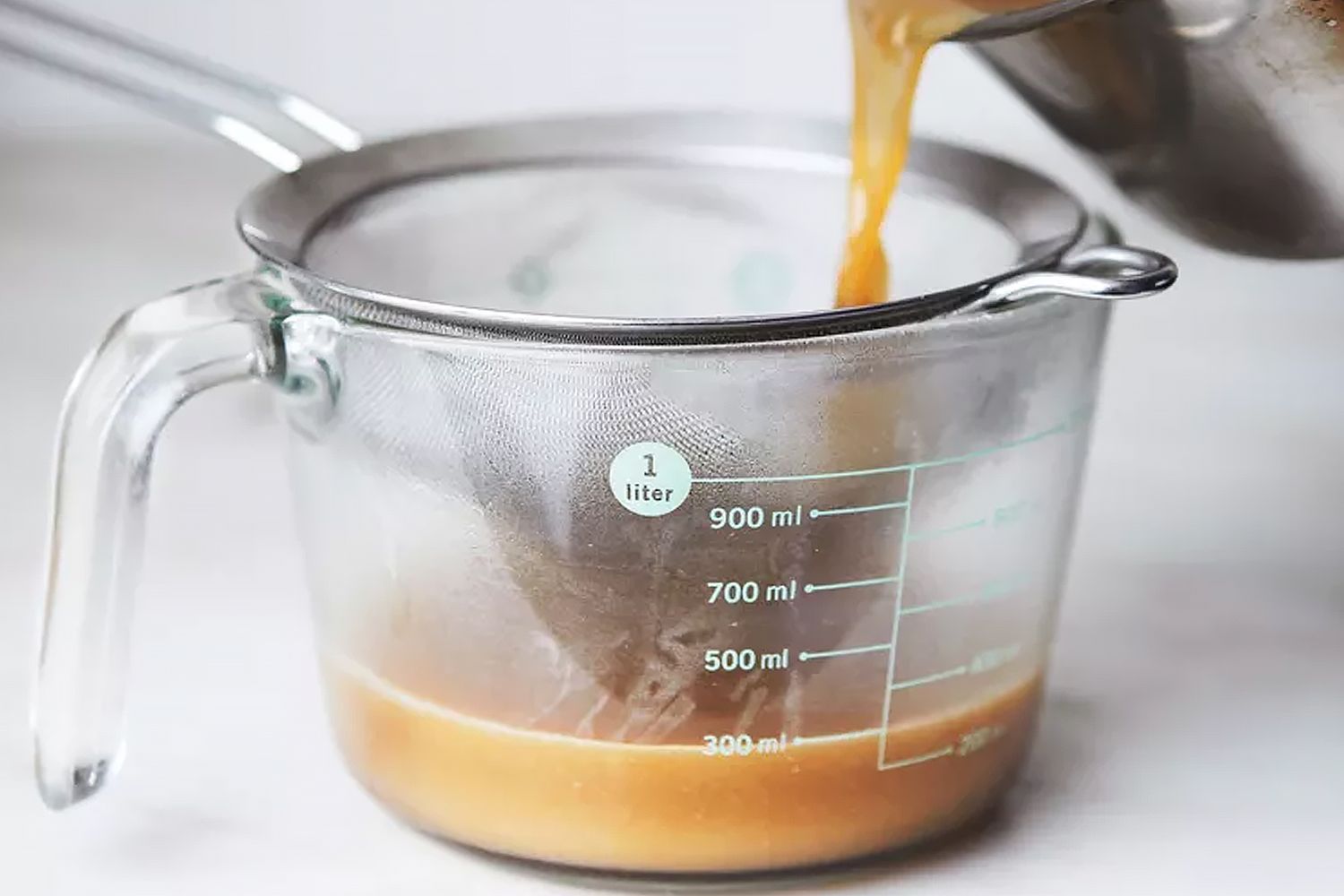 pouring gravy into a measuring cup