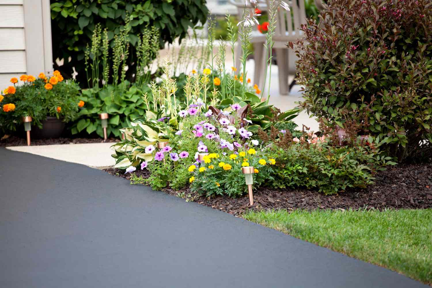 Pretty garden and entryway next to the paved driveway.