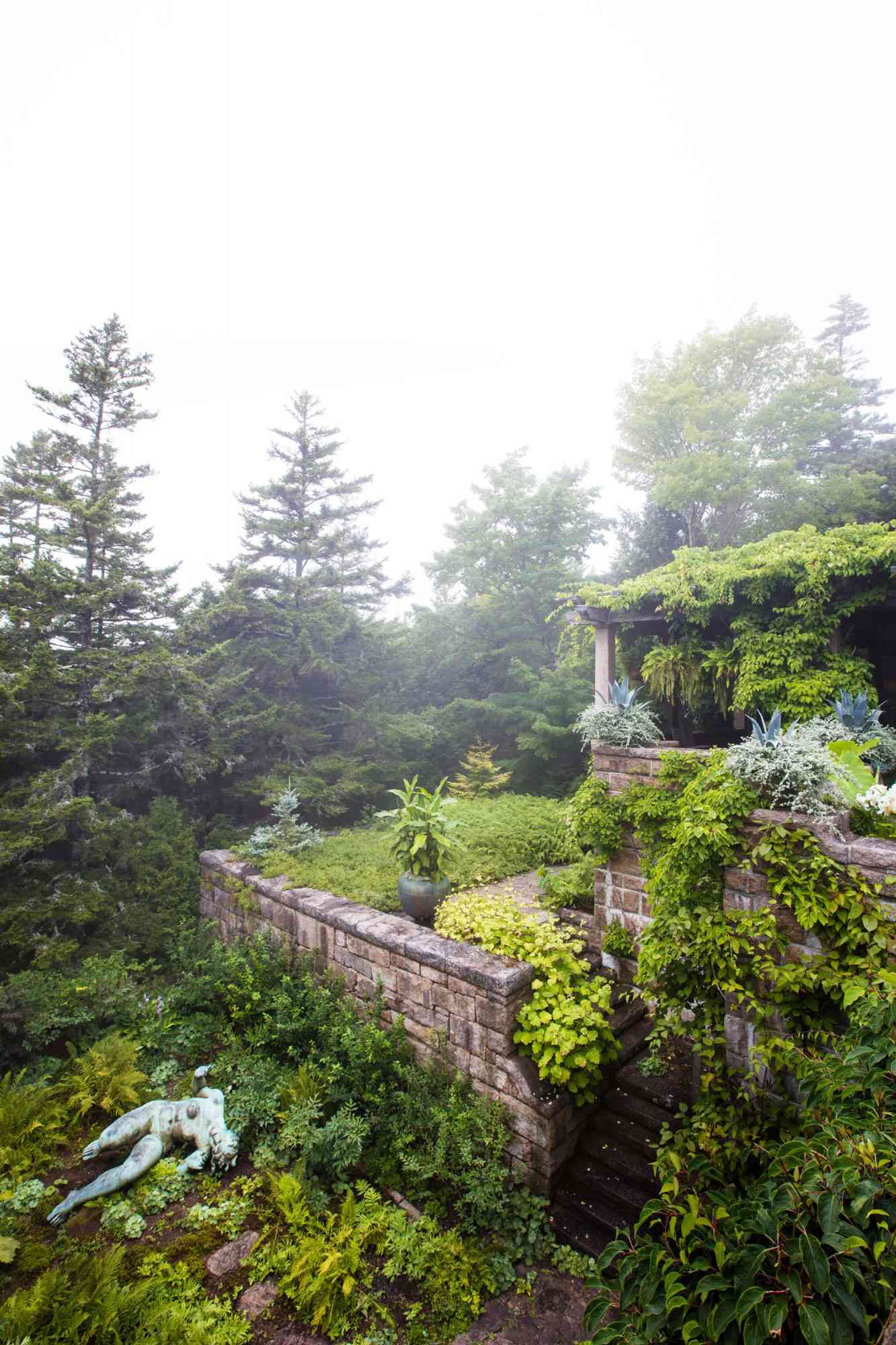 bronze statue among green plants and moss