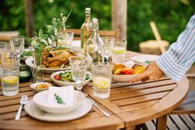 Dinner table with dishes and someone arranging food