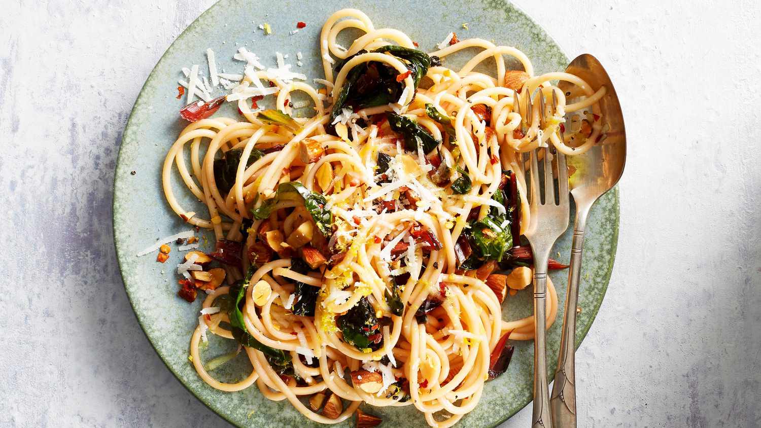 swiss chard almond pasta on plate with spoon