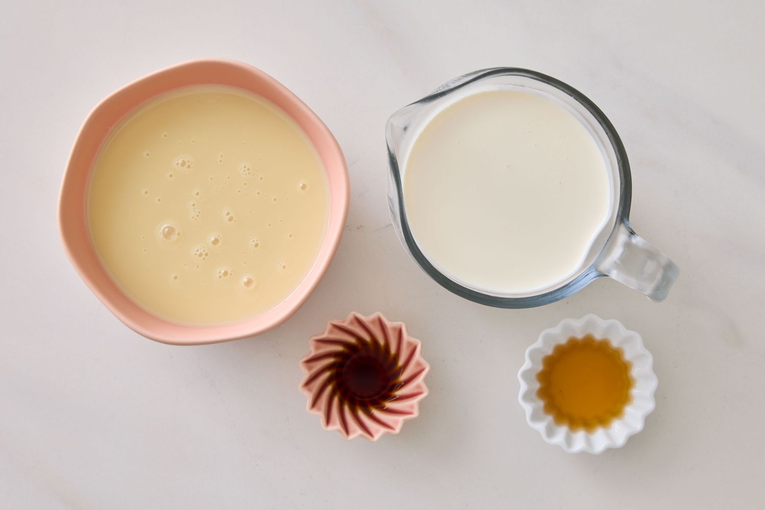 Ingredients arranged for making nochurn vanilla ice cream including condensed milk cream vanilla extract and honey