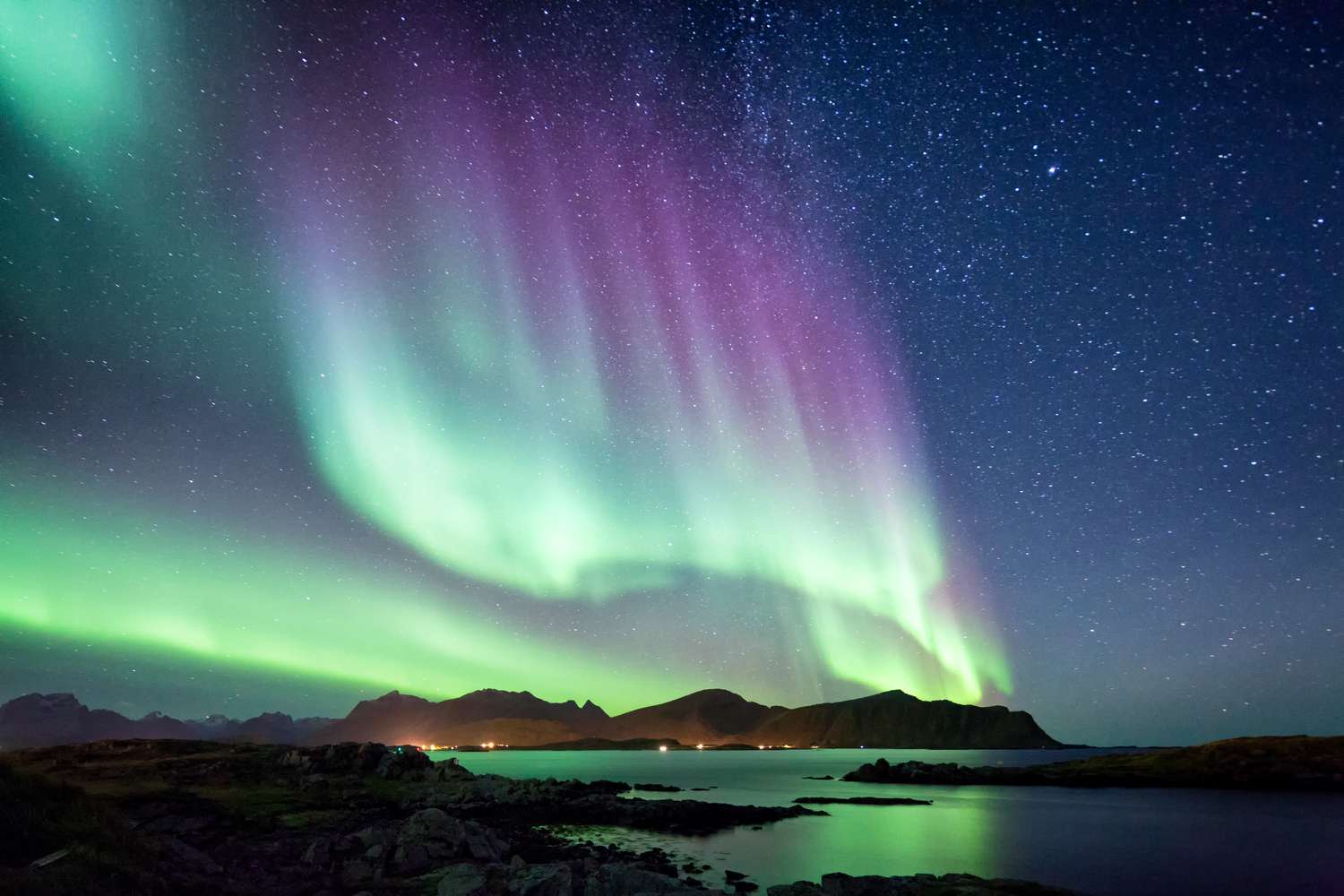 Northern lights over a mountain and water scene