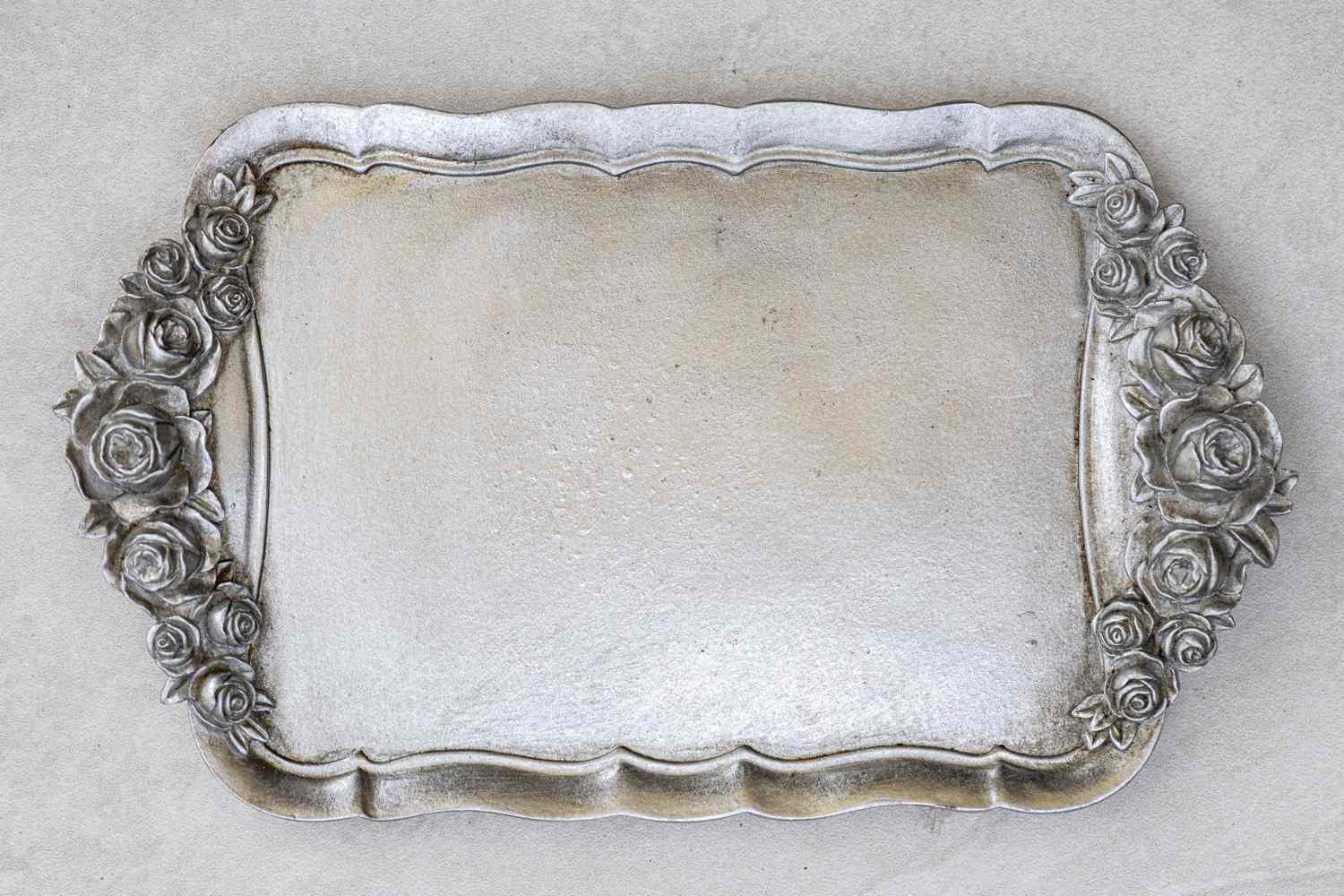 An ornamental tray with rose designs around the rim