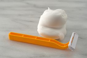 A razor and shaving cream on a surface