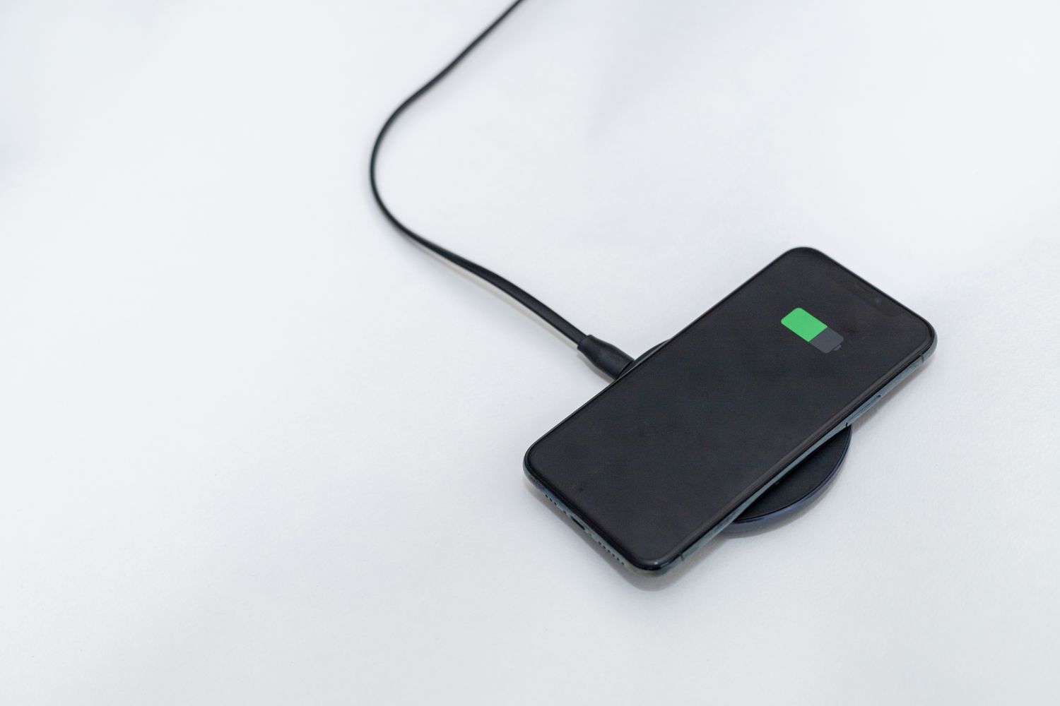 A smartphone charging wirelessly on a pad