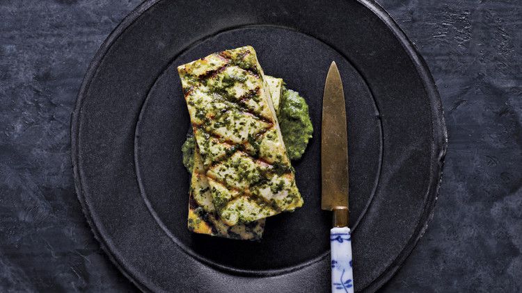tofu with ginger cilantro sauce served on a black plate