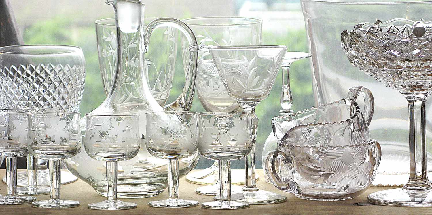 A collection of various cut glass and crystal tableware displayed on a surface