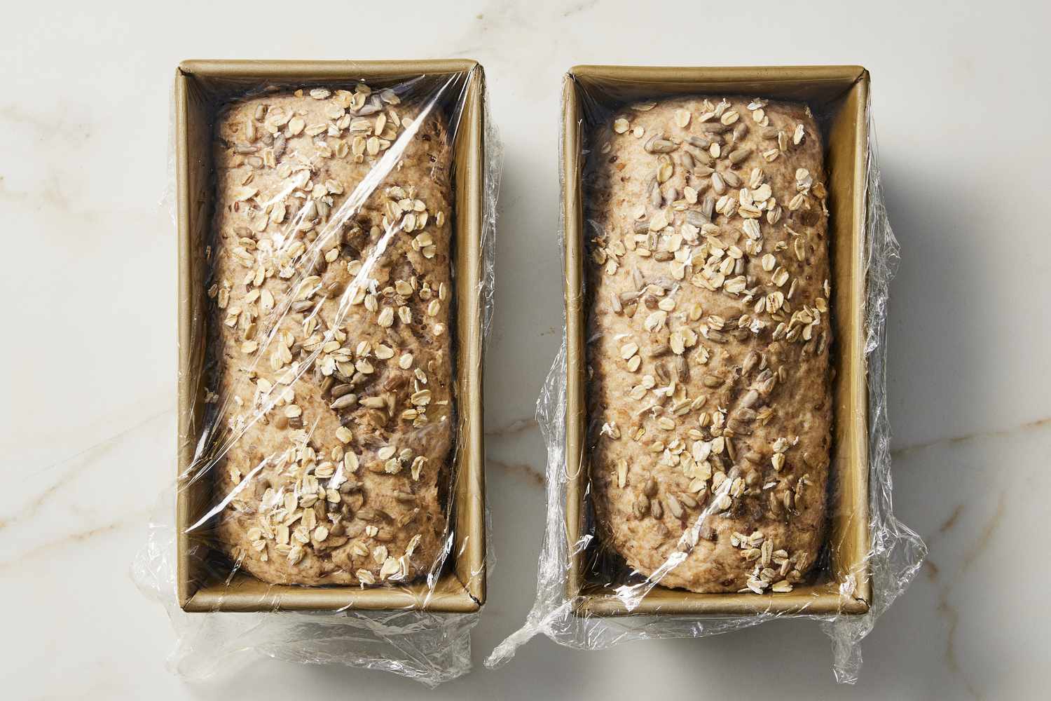 Multigrain bread dough rising in pans