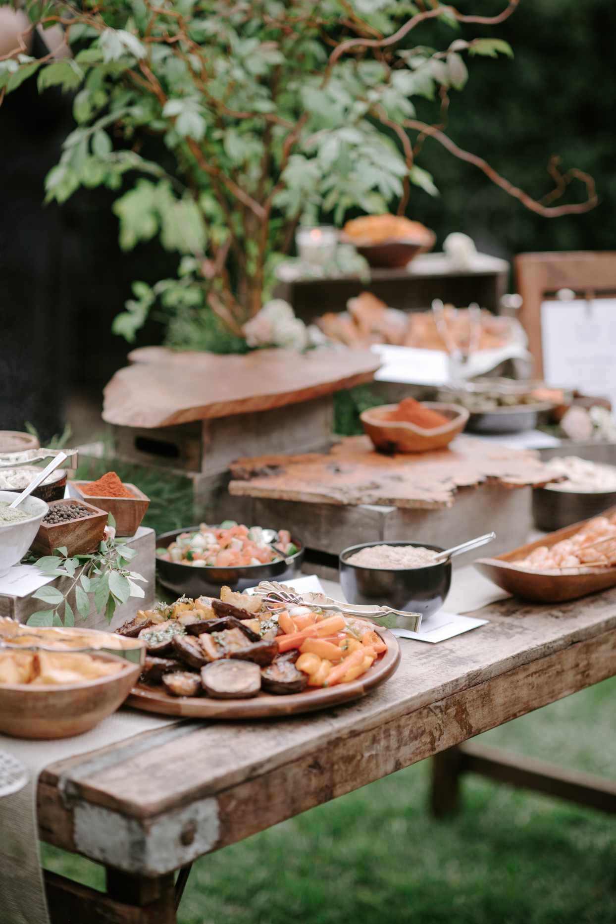 rustic wooden table with trays of wedding food