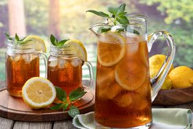 Pitcher of cold ice tea with rural summer background