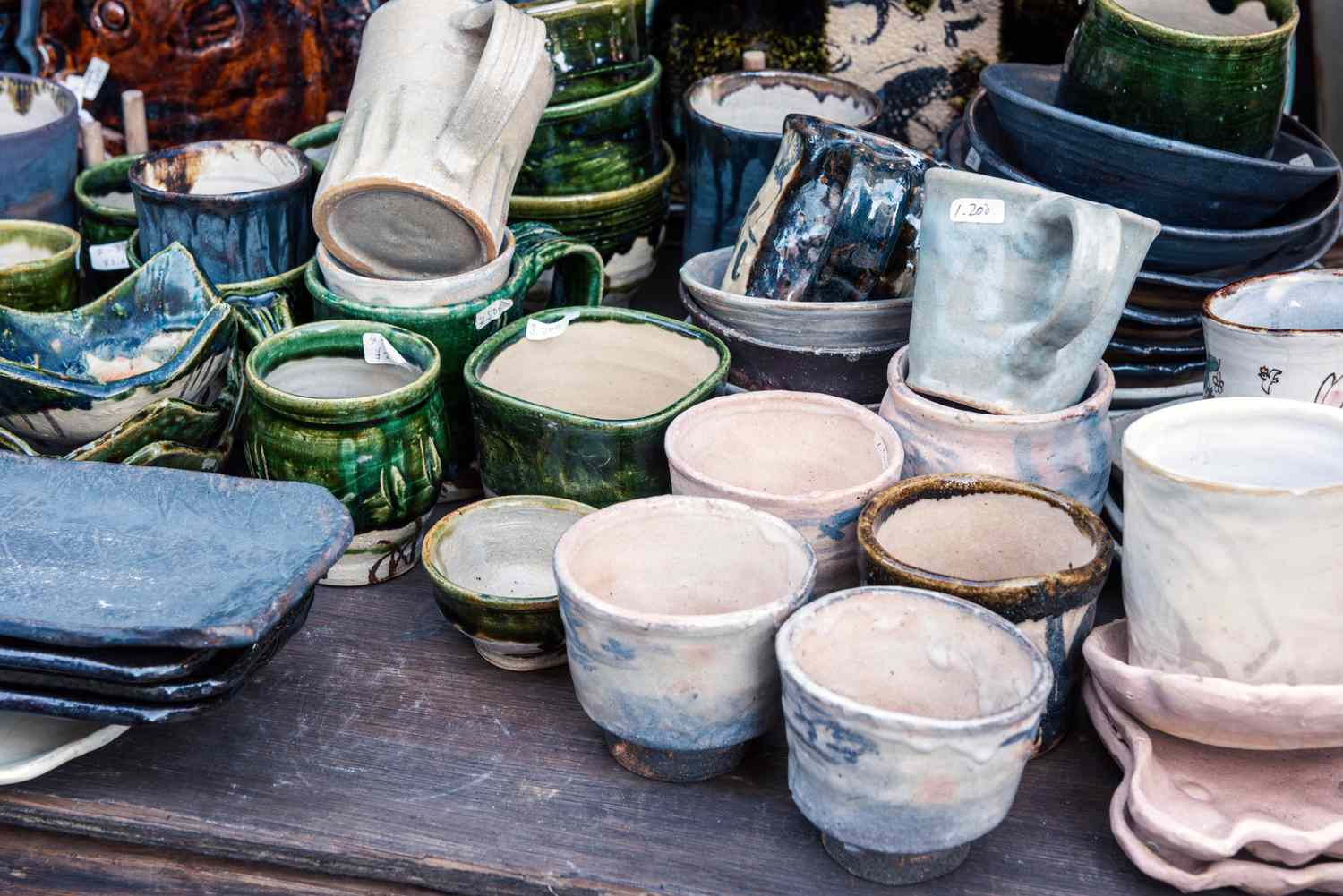A collection of handcrafted ceramic cups and dishes displayed