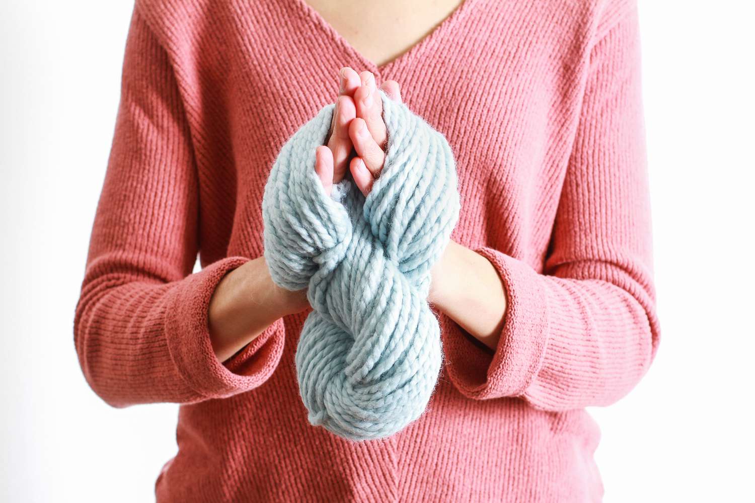 wrapped blue yarn twisted around hands