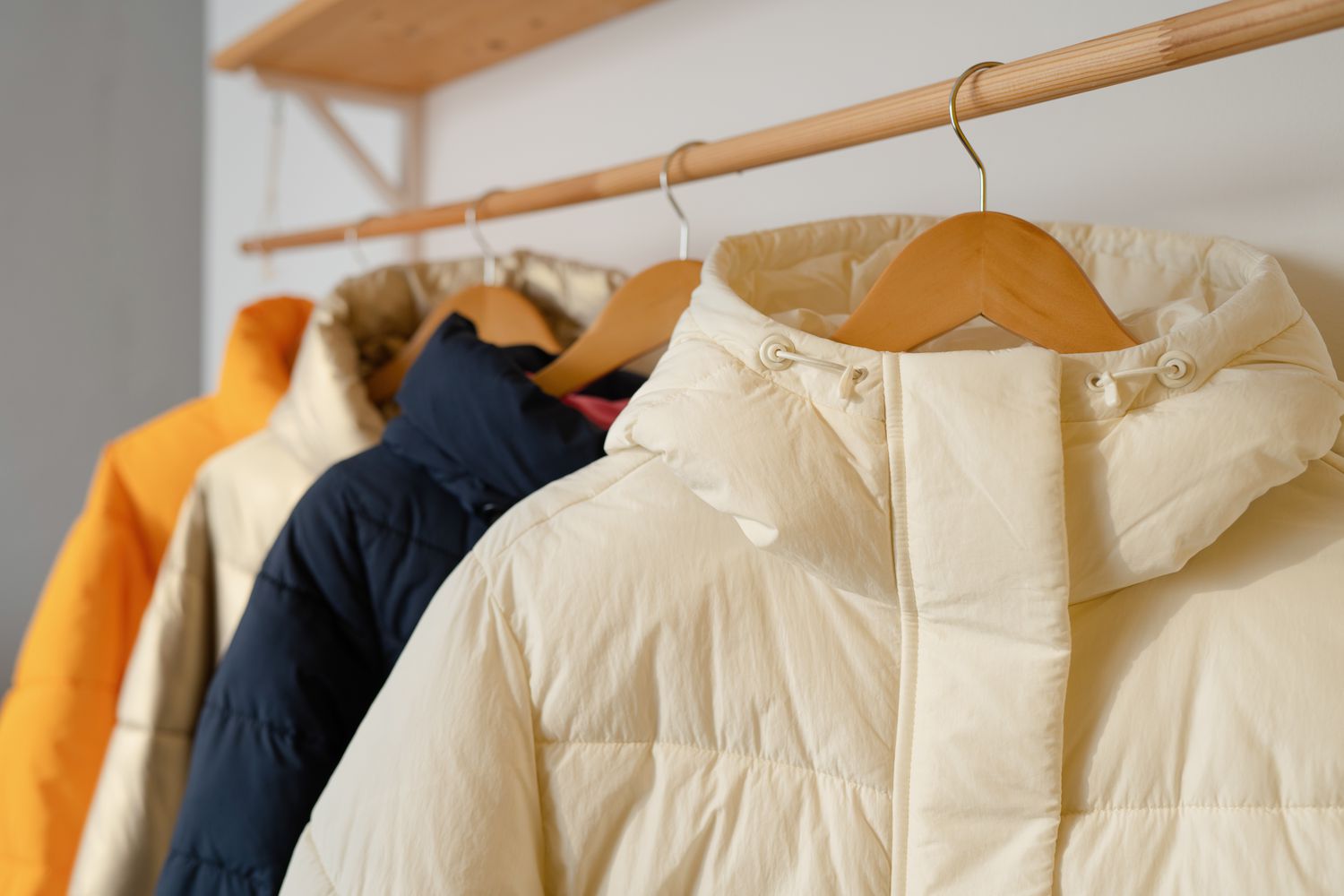 A row of down jackets hang on a white background