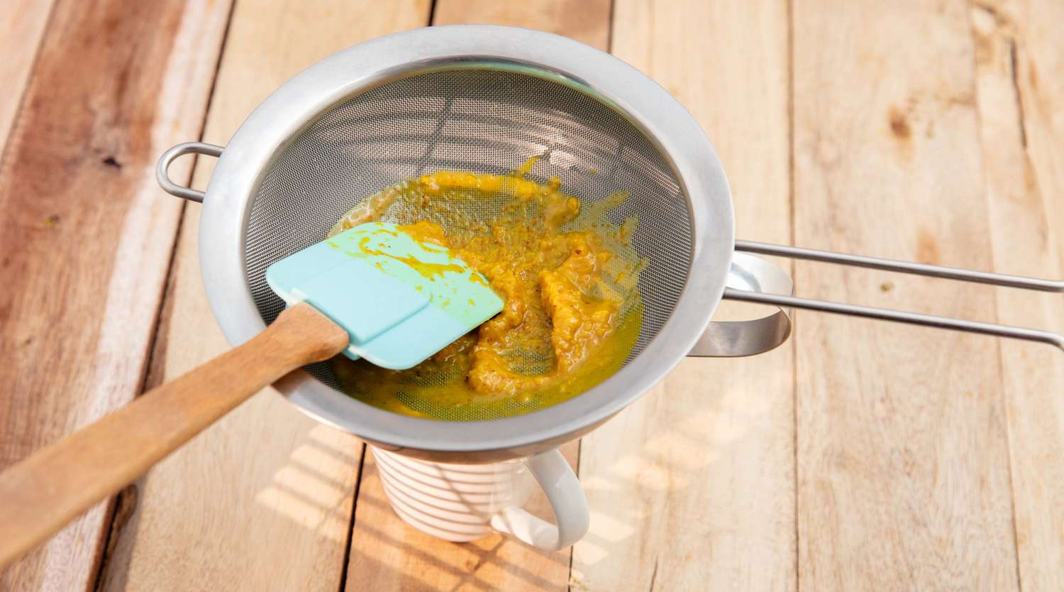 puree fruit in metal sieve