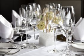 Elegant dining table setup with wine glasses and a small floral centerpiece