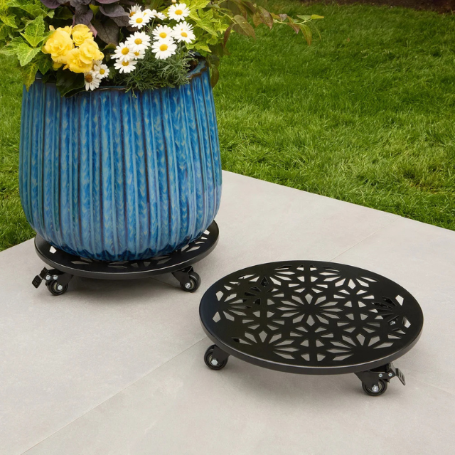 A plant dolly with ornamental design supporting a large blue flowerpot