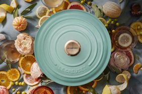 Le Creuset cookware lid surrounded by sliced citrus and flowers