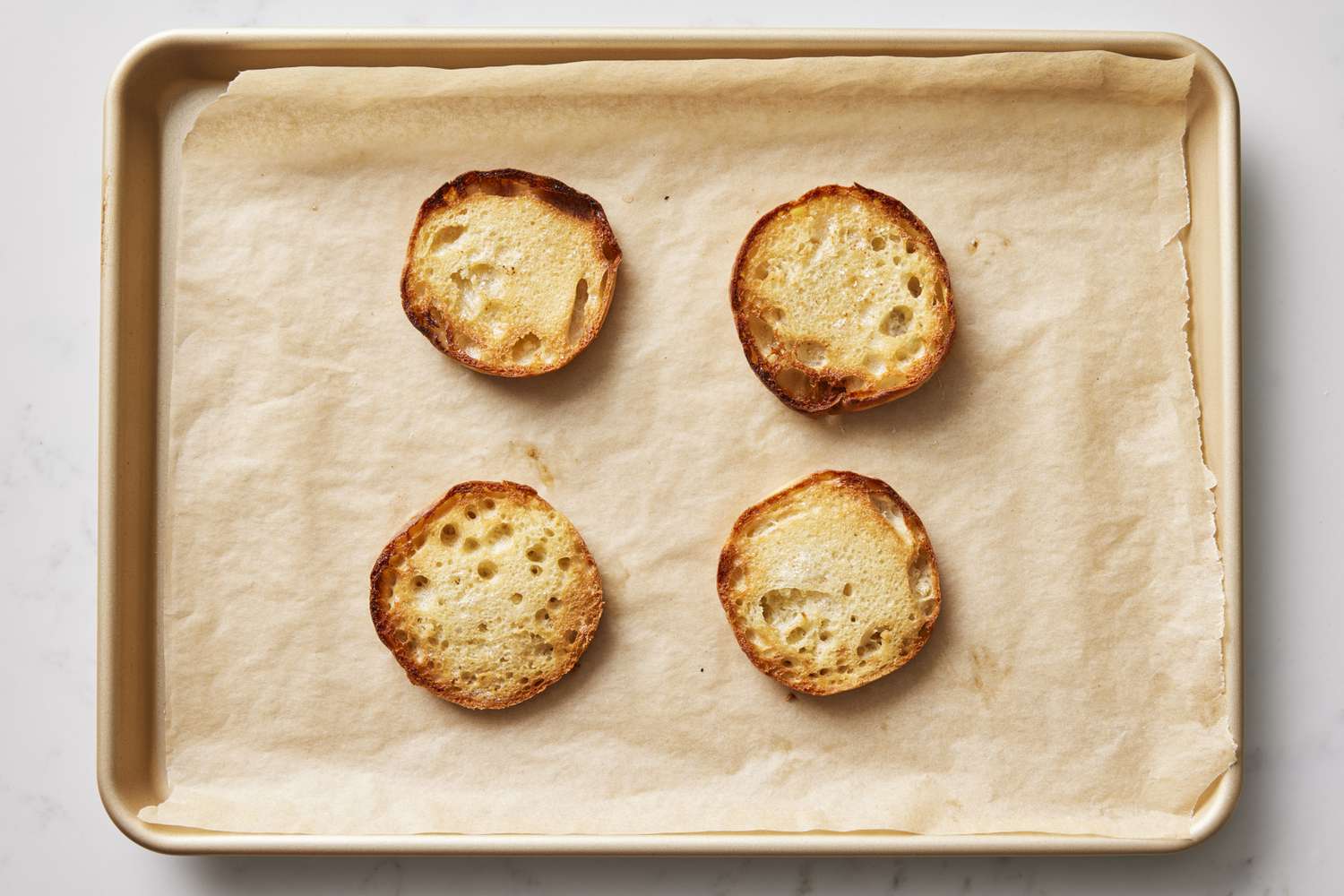 Baked english muffins on baking sheet