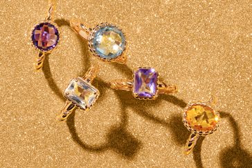 Assorted birthstone rings displayed on a textured surface