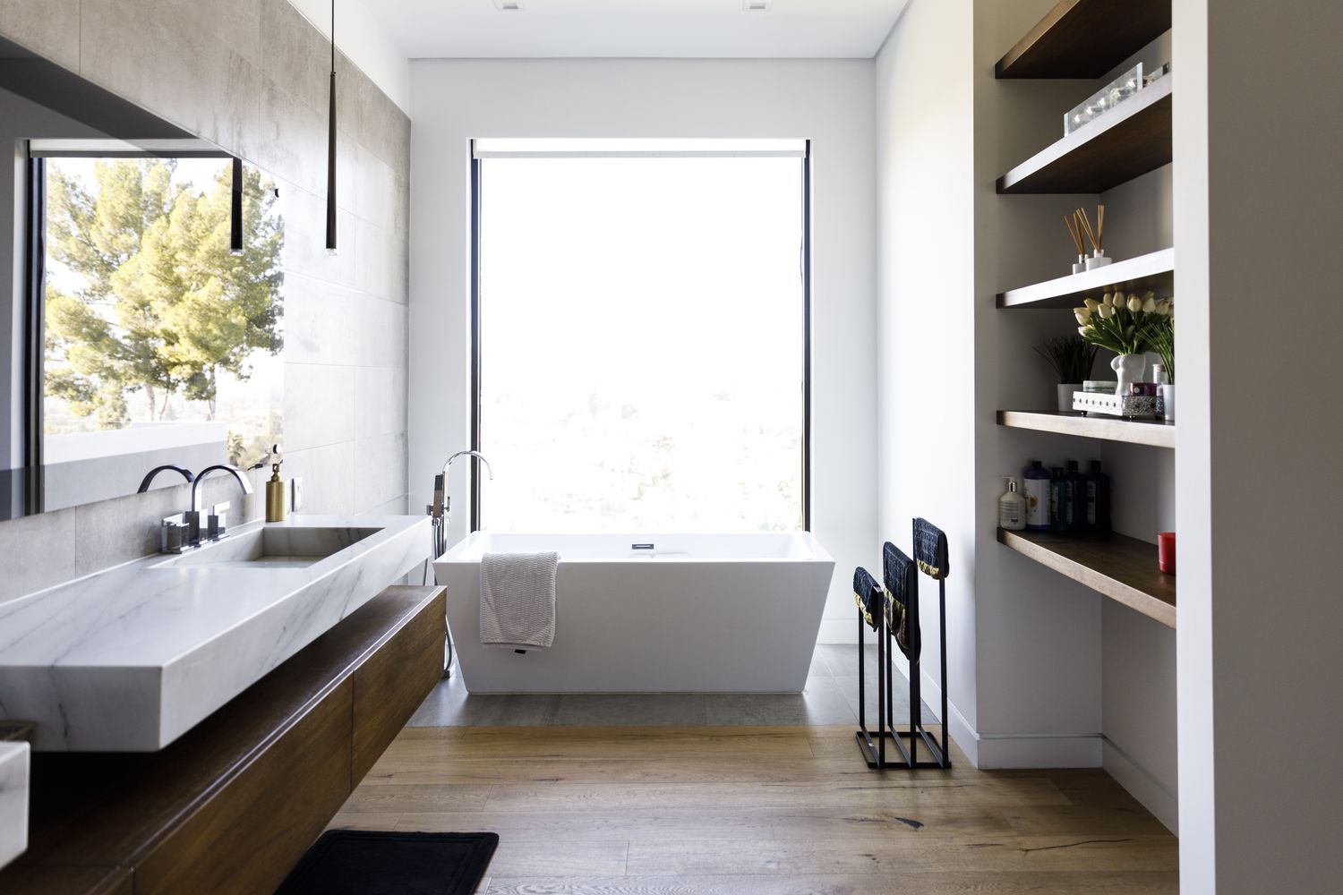 Modern bathroom with a freestanding bathtub floating vanity and open shelving