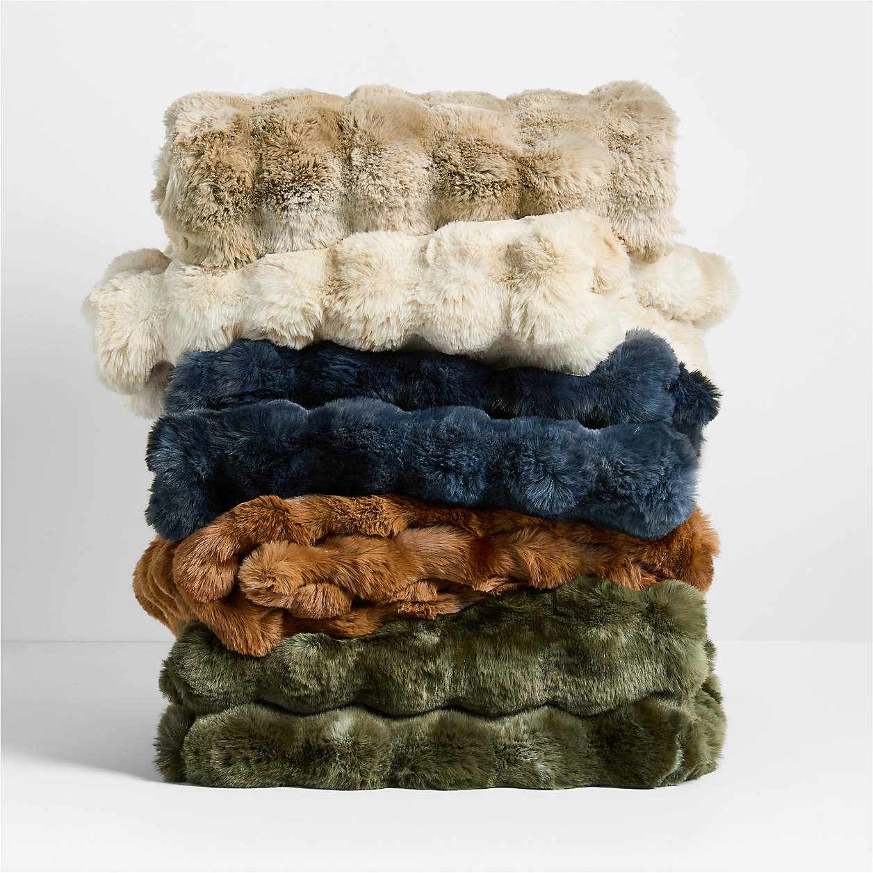 A stack of textured faux fur throws in different colors