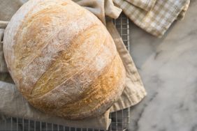 loaf of bread on towel on cooling rack
