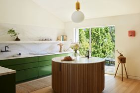 a kitchen with green cabinets and a sphere pendant