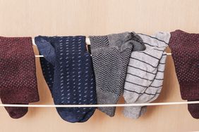 Several socks hanging on a drying rack indoors