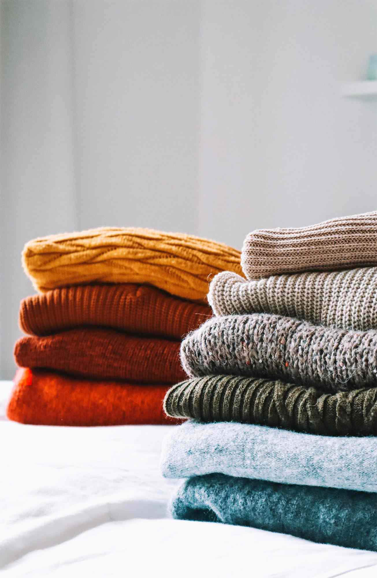 Close-Up Of Sweaters On Bed
